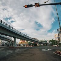 Low angle of empty asphalt crossroad with red traffic light with timer in center of city